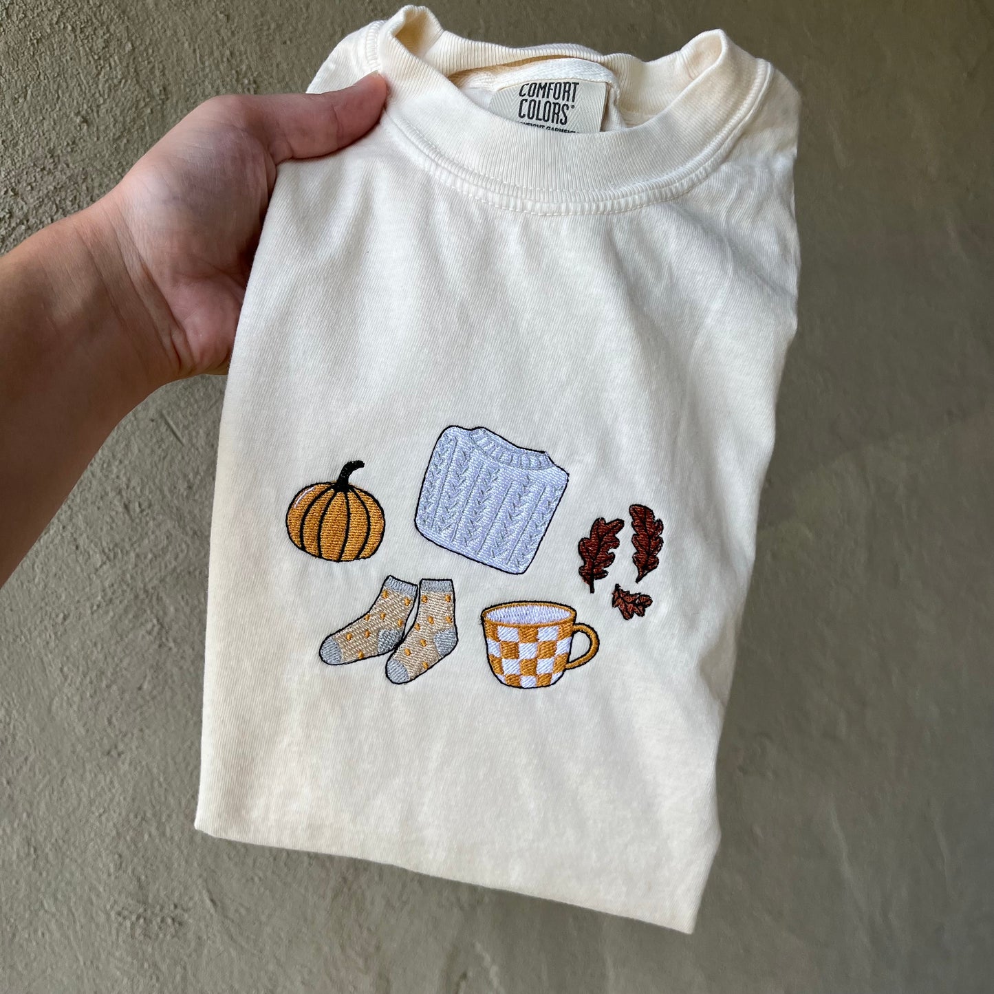 Comfort Colors fall t-shirt with embroidered pumpkin, sweater, socks, coffee, and leaves design