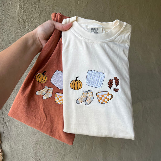 Comfort Colors fall t-shirt with embroidered pumpkin, sweater, socks, coffee, and leaves design